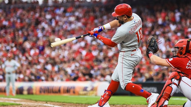 Aug 11, 2025; Cincinnati, Ohio, USA; Philadelphia Phillies designated hitter Kyle Schwarber (12) hits a two-run home run in the eighth inning against the Cincinnati Reds at Great American Ball Park. Mandatory Credit: Katie Stratman-Imagn Images
