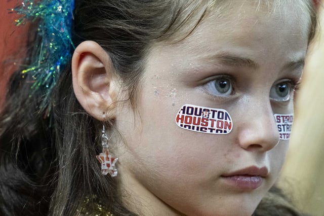 A young fan watches batting practice before an MLB baseball game in Houston, Friday, Aug. 15, 2025.