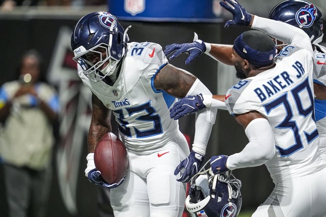 Aug 15, 2025; Atlanta, Georgia, USA; Tennessee Titans safety Kendell Brooks (33) reacts with teammates after running for a touchdown after intercepting a pass against the Atlanta Falcons during the first half at Mercedes-Benz Stadium. Mandatory Credit: Dale Zanine-Imagn Images