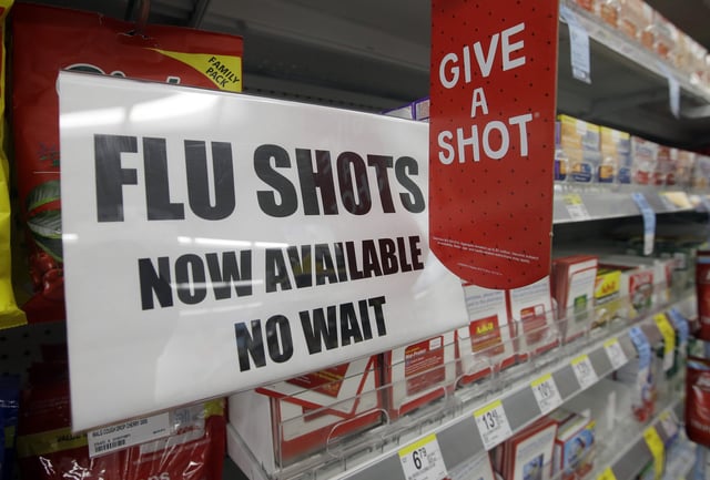 In this Sept. 16, 2014 file photo, a sign telling customers that they can get a flu shot in a Walgreen store is seen in Indianapolis.