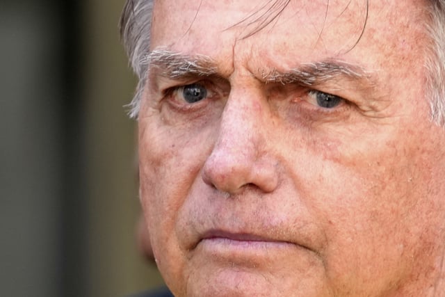 Brazil’s former President Jair Bolsonaro, center, temporarily allowed out of house arrest for medical exams, departs a hospital in Brasília, Brazil, Saturday, Aug. 16, 2025. (AP Photo/Eraldo Peres)