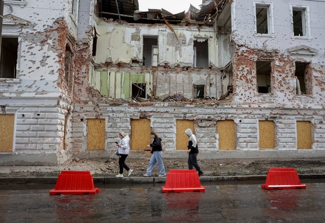 Residents walk at a street near a building damaged by Russian missile strikes, amid Russia's attack on Ukraine, in Sumy, Ukraine June 13, 2025. REUTERS/Sofiia Gatilova/File Photo