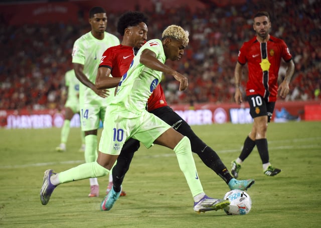Soccer Football - LaLiga - RCD Mallorca v FC Barcelona - Estadi Mallorca Son Moix, Palma de Mallorca, Spain - August 16, 2025 FC Barcelona's Lamine Yamal in action with RCD Mallorca's Johan Mojica REUTERS/Francisco Ubilla