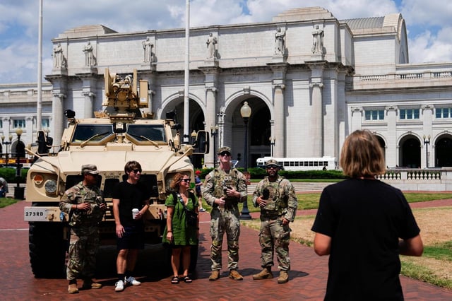 Miembros de la Guardia Nacional del Distrito de Columbia posan para fotografiarse con ciudadanos fuera de la Union Station, el sábado 16 de agosto de 2025, en Washington. (AP Foto/Julia Demaree Nikhinson)