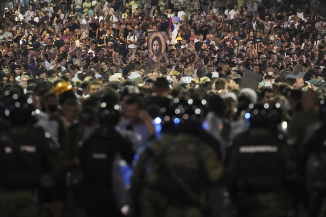 Serbian gendarmerie officers guard a street during an anti-government protest near the Serbian Progressive Party office in Belgrade, Serbia, Friday, Aug. 15, 2025. (AP Photo/Darko Vojinovic)