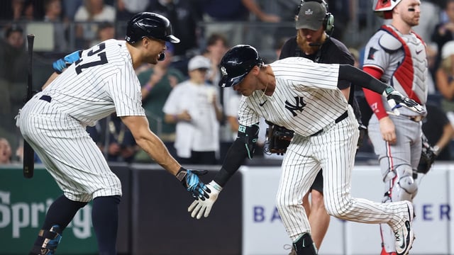 Aug 13, 2025; Bronx, New York, USA; New York Yankees left fielder Cody Bellinger (35) celebrates with right fielder Giancarlo Stanton (27) after hitting a solo home run during the third inning against the Minnesota Twins at Yankee Stadium. Mandatory Credit: Vincent Carchietta-Imagn Images
