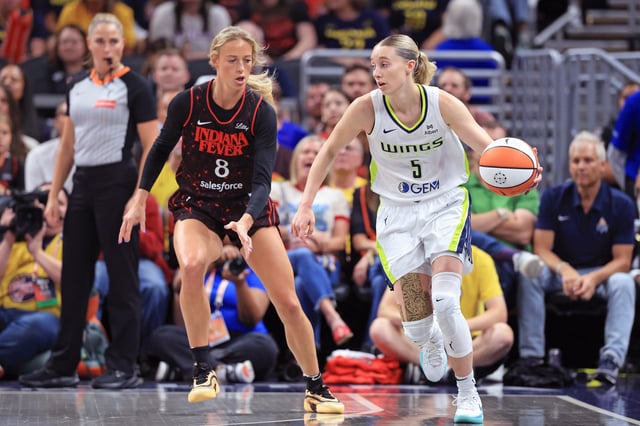 Paige Bueckers #5 of the Dallas Wings makes a move on Sophie Cunningham #8 of the Indiana Fever during the first quarter at Gainbridge Fieldhouse on August 12, 2025 in Indianapolis, Indiana.