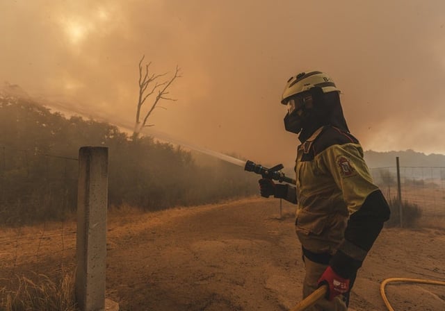 Uno de los bomberos de La Coruña, combatiendo el fuego en la explotación bocina de Simón