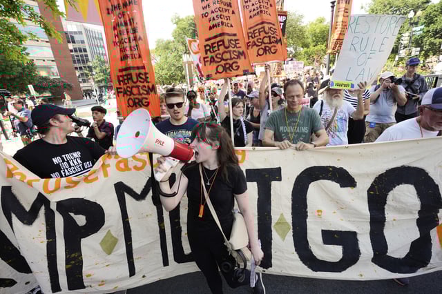 Activists carrying signs march to the White House to protest President Donald Trump&#39;s federal takeover of policing of the District of Columbia, Saturday, Aug. 16, 2025, in Washington.