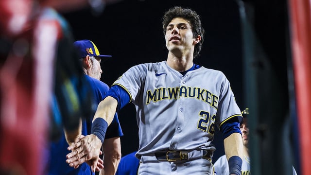 Aug 16, 2025; Cincinnati, Ohio, USA; Milwaukee Brewers designated hitter Christian Yelich (22) high fives teammates after the victory over the Cincinnati Reds at Great American Ball Park. Mandatory Credit: Katie Stratman-Imagn Images