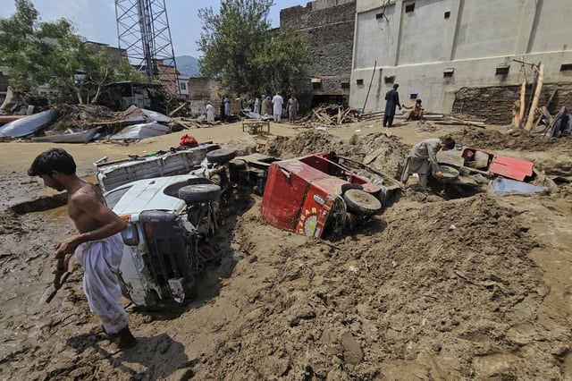 Local residents remove mud to recover vehicles from debris after Friday's flash flooding, in Mingora, the main town of Swat Valley, in Pakistan's northwest, Saturday, Aug. 16, 2025. (AP Photo/Sherin Zada)