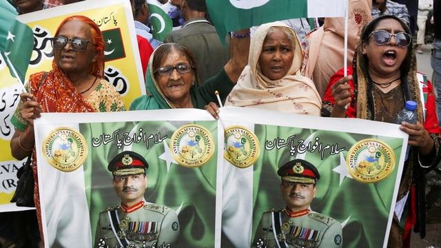 People holding pictures of Field Marshal Asim Munir during a rally in support of Pakistan Army in Karachi.