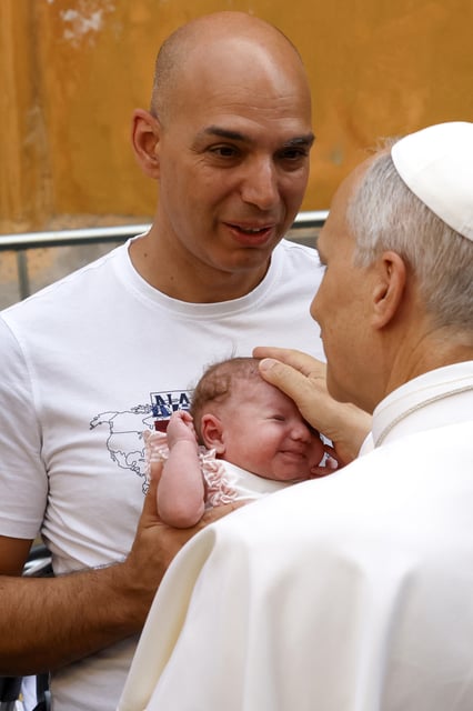 Pope Leo XIV caresses a baby as he arrives to celebrate a Mass at the Sanctuary of Santa Maria della Rotonda in Albano Laziale, near Rome, Sunday, Aug. 17, 2025. (AP Photo/Riccardo De Luca)