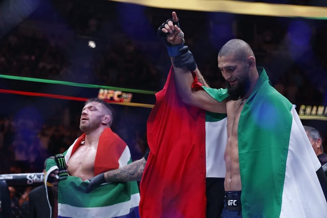 Aug 16, 2025; Chicago, Illinois, UNITED STATES; Khamzat Chimaev (blue gloves) reacts after the fight against Dricus Du Plessis Murphy (red gloves) during UFC 319 at United Center. Mandatory Credit: Kamil Krzaczynski-Imagn Images