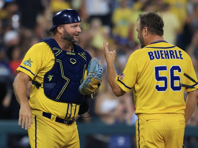 Former White Sox players A.J. Pierzynski, left, and Mark Buehrle talk as Buehrle takes the mound to throw for the Savannah Bananas in the seventh inning against the Firefighters on Aug. 15, 2025, at Rate Field. (John J. Kim/Chicago Tribune)