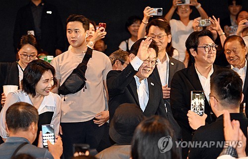 President Lee Jae Myung (C), first lady Kim Hea Kyung (L) and actor Cho Jin-woong (R) attend a screening of "La Resistance," which follows the history of Korean independence fighters, at a theater in central Seoul on Aug. 17, 2025. (Pool photo) (Yonhap)