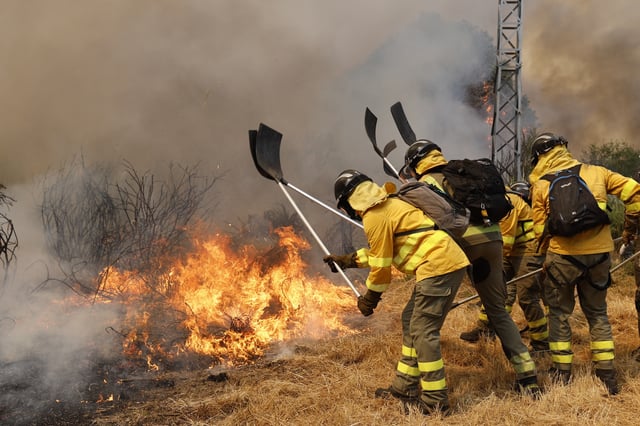Firefighters battle a wildfire in Veiga das Meas, northwestern Spain, Saturday, Aug. 16, 2025. (AP Photo/Lalo R. Villar)