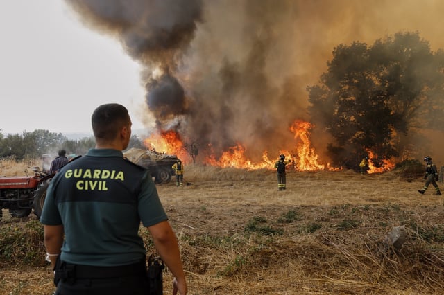 Firefighters battle a wildfire in Veiga das Meas, northwestern Spain, Saturday, Aug. 16, 2025. (AP Photo/Lalo R. Villar)