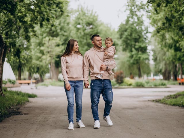 Young family with their little baby child in park
