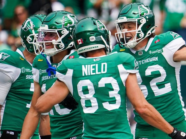 Saskatchewan Roughriders receiver Joe Robustelli (right) celebrates with teammates after scoring a touchdown against the Hamilton Tiger-Cats during the second half of CFL football action in Regina, on Saturday, August 16, 2025.
