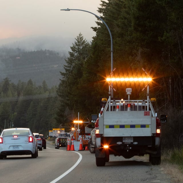 A road crew awaits a potential closure along highway 4 as the Wesley Ridge wildfire burns out-of-control at Cameron Lake near Coombs, B.C., Sunday, Aug. 3, 2025. THE CANADIAN PRESS/Chad Hipolito