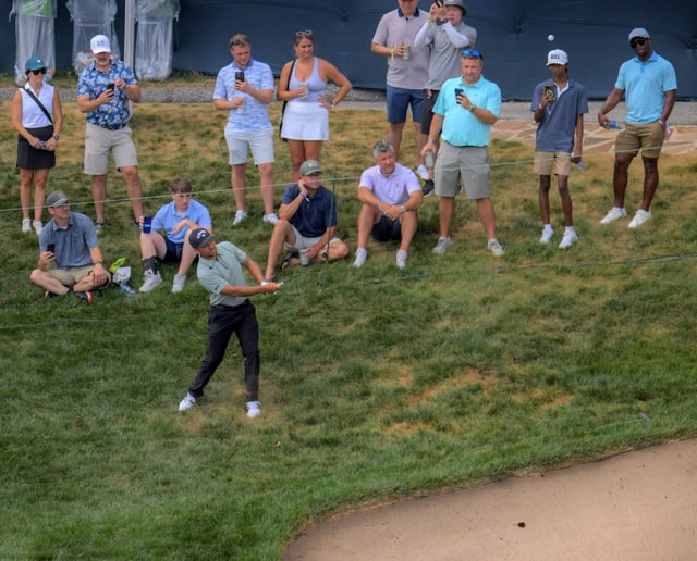 Spectators watch Xander Schauffele play to the 18th hole in which he double bogeyed during the first round of the BMW Championship at Caves Valley Golf Club. (Karl Merton Ferron/Staff)