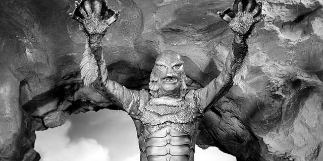 The Gill-man raises its arms in Creature from the Black Lagoon.