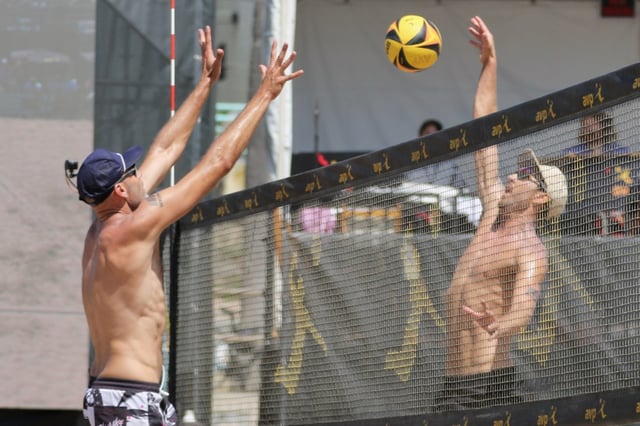 Miles Evans, right, tries for a hit over Phil Dallhauser in the men’s final at the AVP Manhattan Beach Open on Sunday, Aug. 17, 2025. (Photo by Howard Freshman, Contributing Photographer)