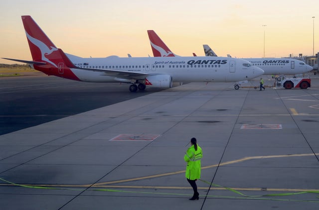 Workers can be seen near Qantas Airways, Australia's national carrier, Boeing 737-800 aircraft on the tarmac at Adelaide Airport, Australia, August 22, 2018. REUTERS/David Gray/File Photo