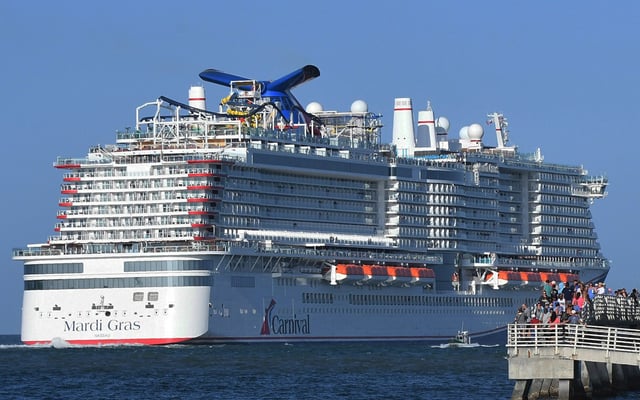 PORT CANAVERAL, FLORIDA, UNITED STATES - JULY 31: People gather on the fishing pier to watch the new Carnival Cruise Line ship Mardi Gras as it departs on its maiden voyage, a seven-day cruise to the Caribbean from Port Canaveral, Florida on July 31, 2021. This is the first cruise from Port Canaveral with paying passengers since March of 2020 when the cruise industry shut down amid the coronavirus pandemic. (Photo by Paul Hennessy/Anadolu Agency via Getty Images)
