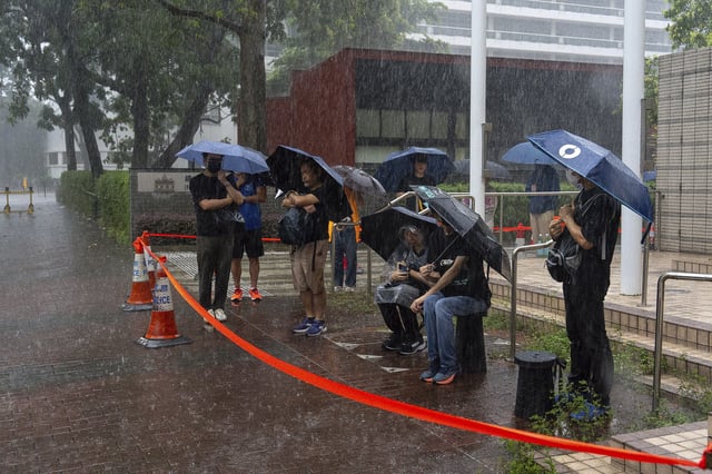 People wait to enter the West Kowloon Magistrates' Courts ahead of the closing statements for Hong Kong activist publisher Jimmy Lai's national security trial in Hong Kong, Thursday, Aug. 14, 2025. (AP Photo/Chan Long Hei)