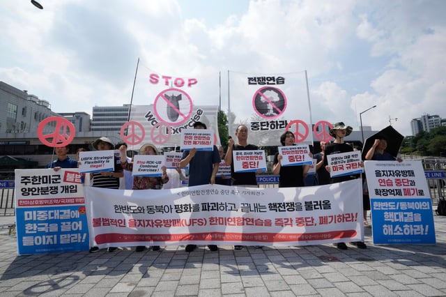 South Korean protesters stage a rally to oppose the joint military exercises, Ulchi Freedom Shield or UFS, between the U.S. and South Korea in front of the presidential office in Seoul, South Korea, Monday, Aug. 18, 2025. The banners read "Stop the military exercise between the U.S. and South Korea." (AP Photo/Ahn Young-joon)