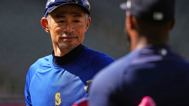 Former Seattle Mariners right fielder Ichiro Suzuki, facing, talks with Mariners right fielder Victor Robles.
