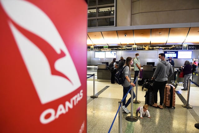 Travelers wait in line after verifying their Covid-19 vaccination status as they check-in for a flight to Sydney, Australia on Qantas Airways Ltd. inside the Tom Bradley International Terminal at Los Angeles International Airport (LAX) on November 1, 2021 in Los Angeles, California.