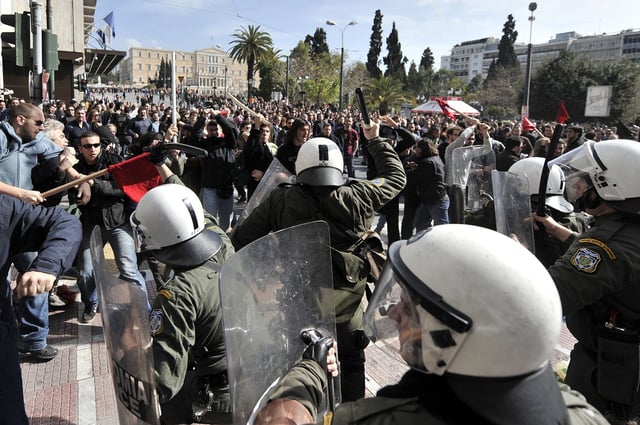 Protesters clash with riot police during a demonstration in the center of Athens on February 24, 2010. Greece ground to a halt on February 24 as unions staged a one-day general strike and thousands of demonstrators took to the streets to protest austerity measures designed to tame a public debt crisis. Schools, government offices and courthouses were all closed while there was also major disruption to public transport, banks, hospitals and state-owned companies.