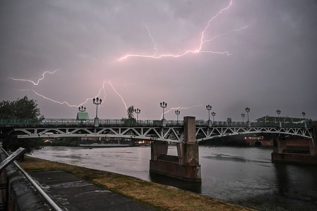 Les éclairs d'un orage sont visibles près du pont Saint-Pierre à Toulouse, le 13 août 2025.