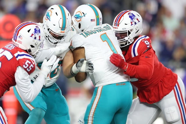FOXBOROUGH, MASSACHUSETTS - SEPTEMBER 17: Tua Tagovailoa #1 of the Miami Dolphins is hit by Matthew Judon #9 of the New England Patriots during the second half at Gillette Stadium on September 17, 2023 in Foxborough, Massachusetts. (Photo by Adam Glanzman/Getty Images)