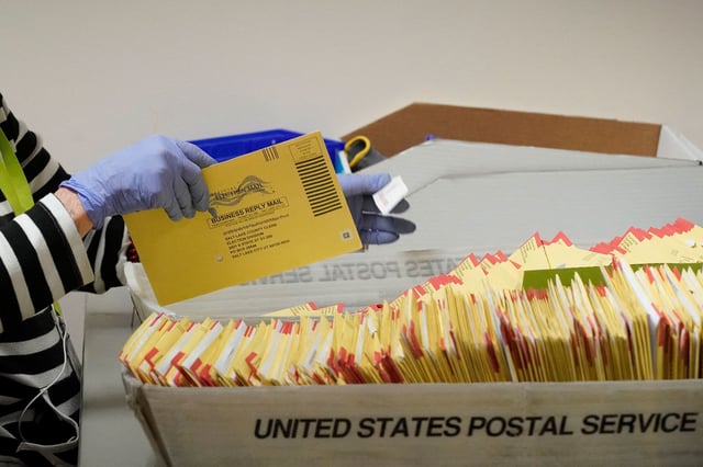 An election worker processes a container of mail-in ballots at the Salt Lake County election offices in Salt Lake City, Utah, on November 4, 2024.