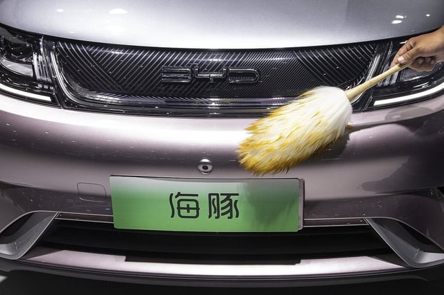 Der Kühlergrill eines Hybridautos wir geputzt