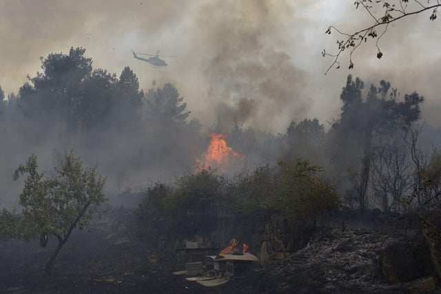 Un helicóptero trata de extinguir el incendio, a 12 de agosto de 2025, en Seixalbo, Ourense, Galicia.