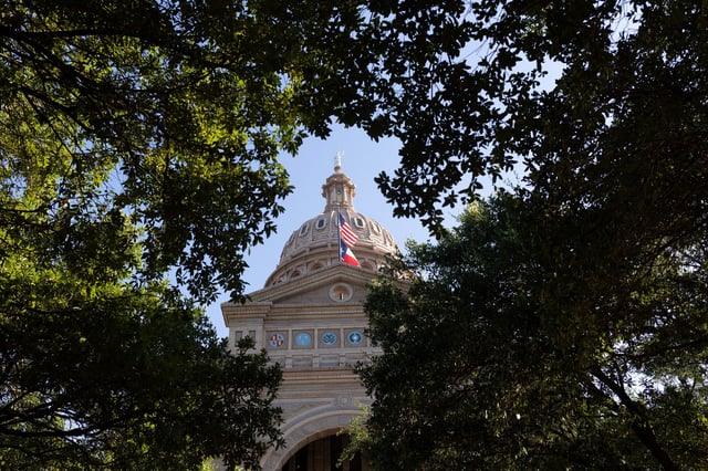 U.S. and Texas state flags fly at the Texas Capitol building, amid a redistricting battle between Republicans and Democratic state lawmakers in Austin, Texas, U.S., August 18 2025. REUTERS/Nuri Vallbona