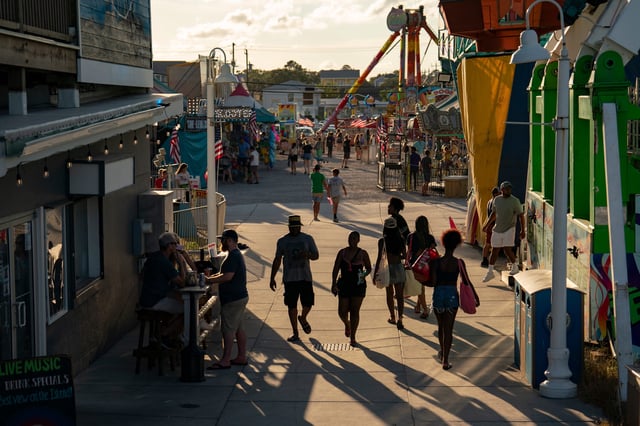 People walk on the boardwalk on September 1, 2024 in Carolina Beach, North Carolina. Airports, highways, beaches and theme parks are expected to be packed across the U.S. this Labor Day in what the TSA expects to be the busiest on record.