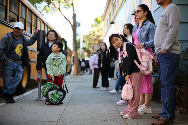 Families wait for school buses outside Buena Vista Horace Mann to take their kids to their temporary classrooms at June Jordan High School on Aug. 18, 2025. Photo by Abigail Van Neely.