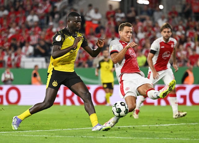 Soccer Football - DFB Cup - First Round - Rot-Weiss Essen v Borussia Dortmund - Stadion Essen, Essen, Germany  - August 18, 2025 Borussia Dortmund's Serhou Guirassy in action with Rot-Weiss Essen's Michael Schultz REUTERS/Teresa Kroeger