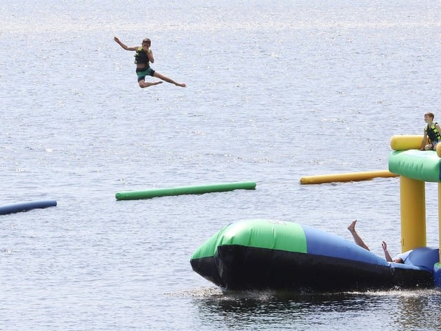 During a heat, a child soars into the air at the Splash N Go Adventure Parks inflatable water park on Ramsey Lake in Sudbury, Ont. on Monday July 28, 2025. 