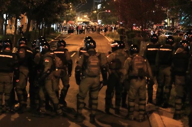 Serbian gendarmerie officers chase protesters during an anti-government protest in Belgrade, Serbia, Monday, Aug. 18, 2025. (AP Photo/Darko Vojinovic)