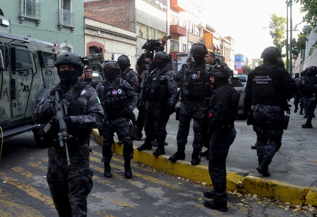 Fotografía de archivo de varios soldados y agentes federales mexicanos mientras participan en el translado de un narcotraficante. EFE/STR