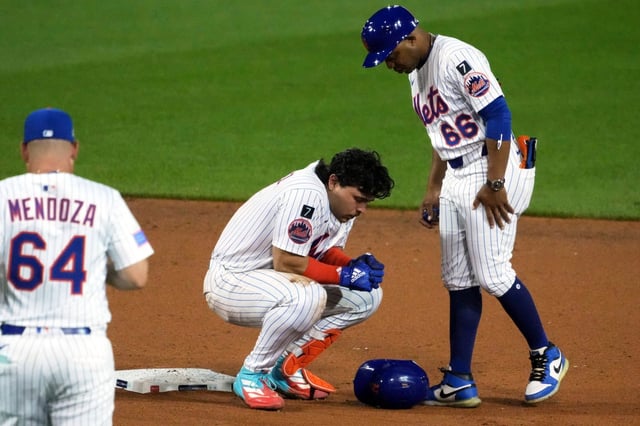 New York Mets&#39; Francisco Alvarez, center, is tend to by first base coach Antoan Richardson (66) and manager Carlos Mendoza after being injured sliding into second during the seventh inning of the Little League Classic baseball game against the Seattle Mariners at Bowman Field in Williamsport, Pa., Sunday, Aug. 17, 2025. (AP Photo/Gene J. Puskar)