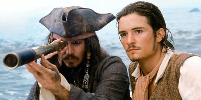 Jack Sparrow (Jonny Depp) looking through a telescope with Will Turner (Orlando Bloom) beside him in The Pirates of the Caribbean: Curse of the Black Pearl.