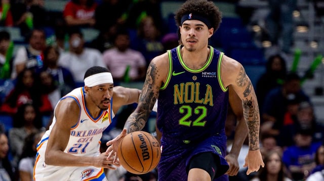 Apr 13, 2025; New Orleans, Louisiana, USA; New Orleans Pelicans guard Lester Quinones (22) dribbles against Oklahoma City Thunder guard Aaron Wiggins (21) during the second half at Smoothie King Center. Mandatory Credit: Stephen Lew-Imagn Images
